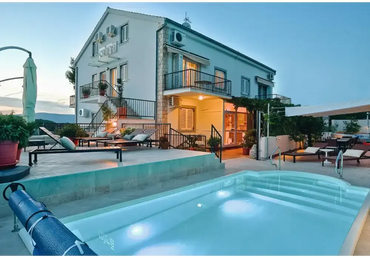 Modern glasfiberpool Aves med avrundad trappa och kaklad omgivning vid villa