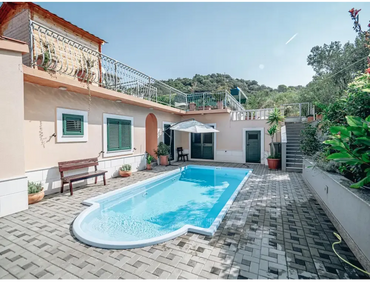 Glasfiberpool Aves med romersk trappa i rektangulär form med kurvad ände, klarblått vatten och vita kakelkanter