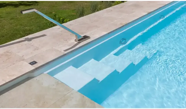Modern rektangulär pool med hög vattenlinje och sluttande botten