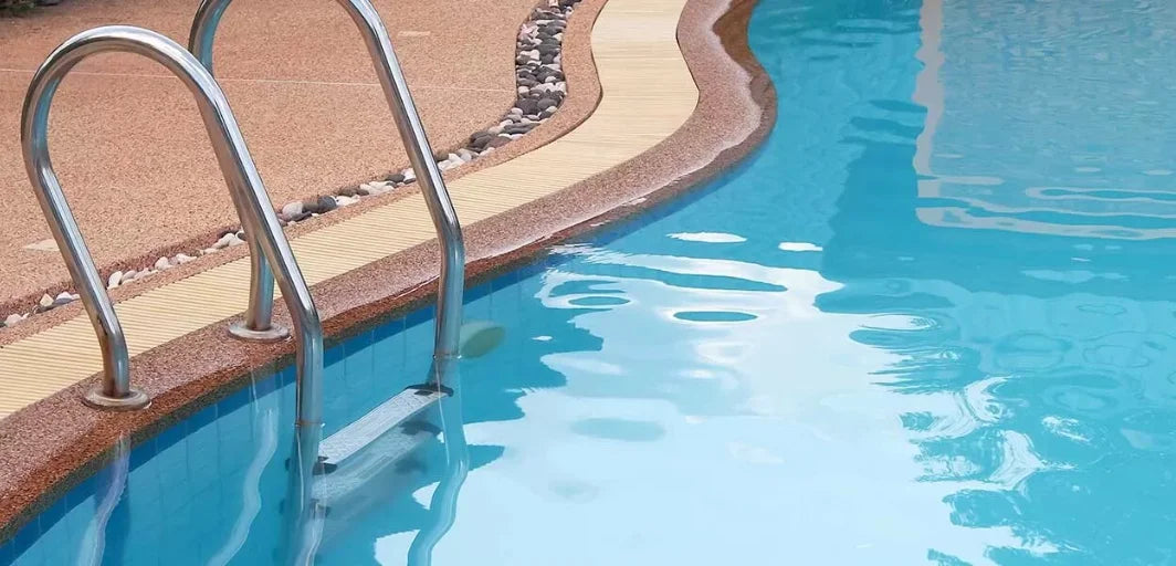 Glänsande krom poolstege med böjda handtag i poolmiljö