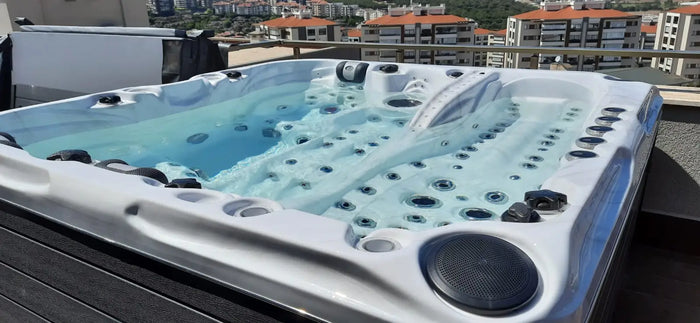 Vit spabad med svarta detaljer och flera jetmunstycken fyllt med klart blått vatten för pool och pooltak