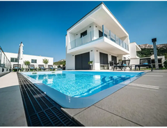 Modern blå rektangulär glasfiberpool Aruba med kaklad omgivning och vit villa