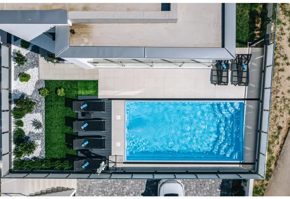 Rektangulär blå glasfiberpool Aruba med klart vatten och kakelkanter