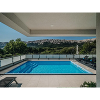 Glasfiberpool Aruba 800 med rektangulär form, klarblått vatten och grå kaklad kant