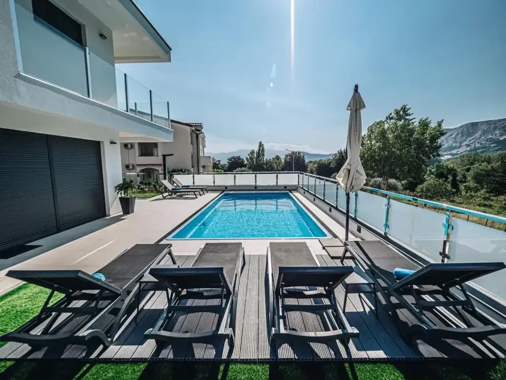 Rektangulär glasfiberpool Aruba Plus med blått klart vatten och glasräcke