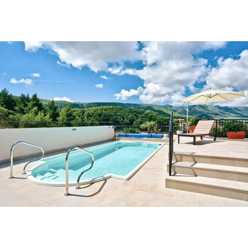 Glasfiberpool Aves 705 med klarblått vatten, vit kakel och avrundad trappa