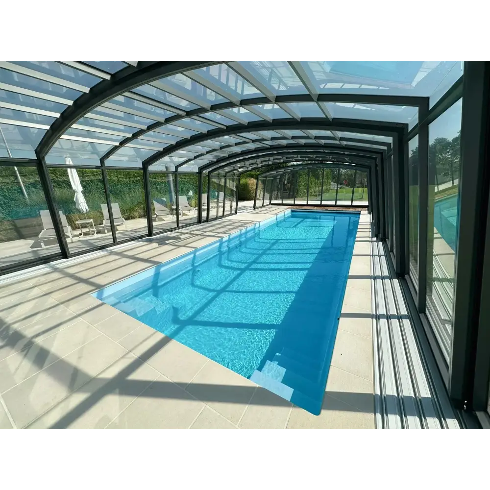 Lång rektangulär Bahama trädgårdspool med klart blått vatten och pooltak i glas