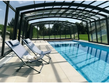 Ljusblå tygfåtölj med metallram vid glasfiberpool Bahama