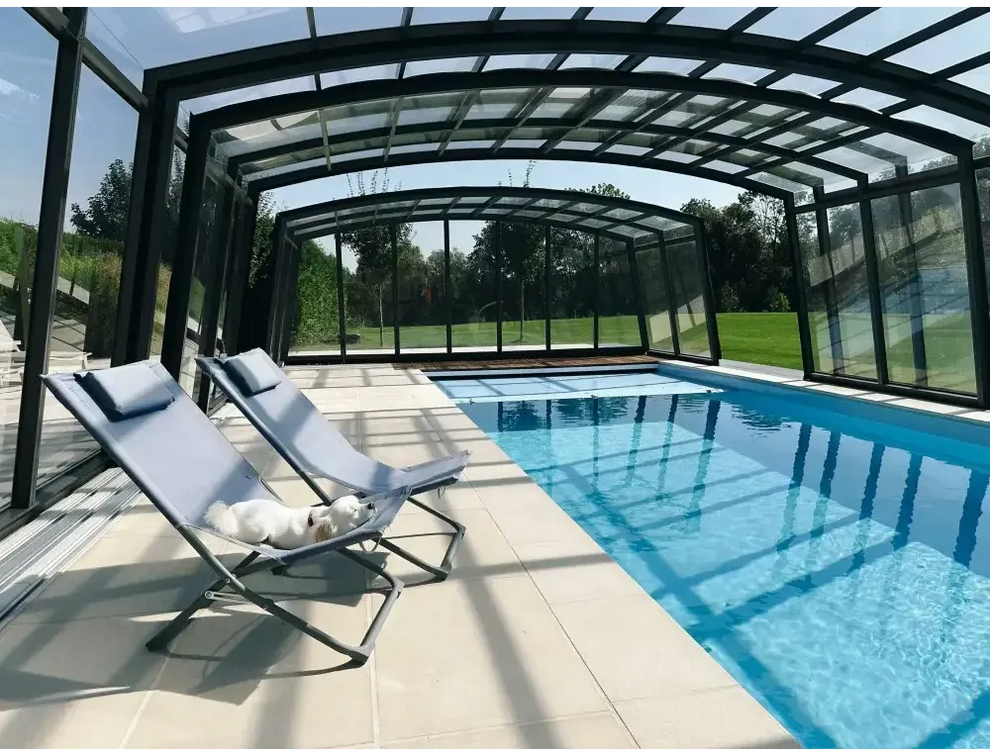 Ljusblå tygfåtölj med metallram vid glasfiberpool Bahama