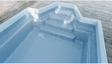Glasfiberpool Grenada med intressant form och bekväma sittplatser i ljusblått