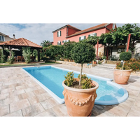 Terrakottakruka med repdetalj runt kanten i Haiti trädgårdspool med avrundad trappa