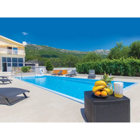 Svart rottingbord med bananer, apelsiner och gul vätska vid Glasfiberpool Jamaika