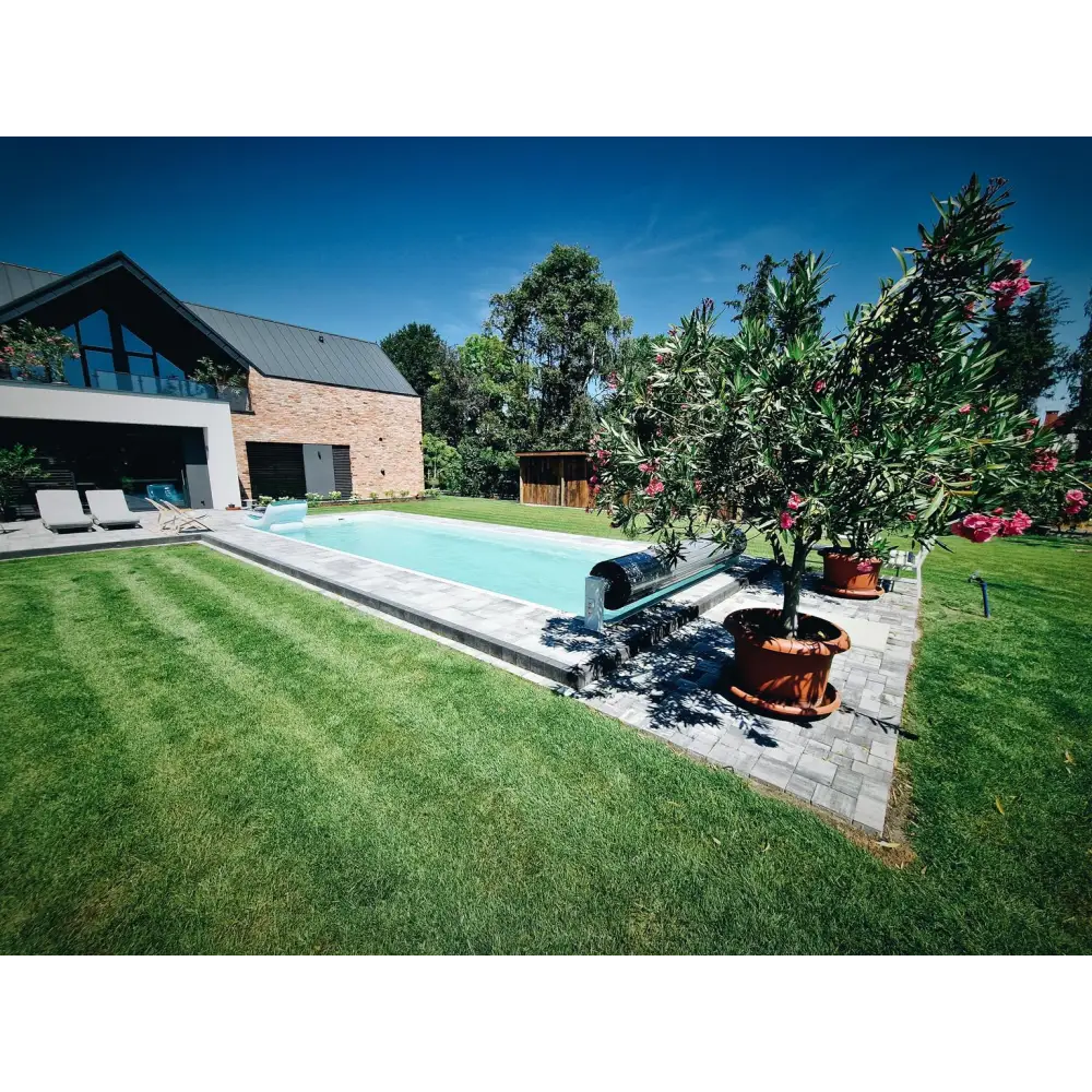 Glasfiberpool Jamaika rektangulär pool med klart blått vatten och gräsmatta