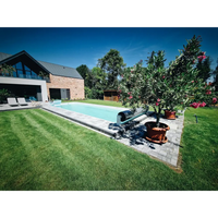 Glasfiberpool Jamaika rektangulär pool med klart blått vatten och gräsmatta