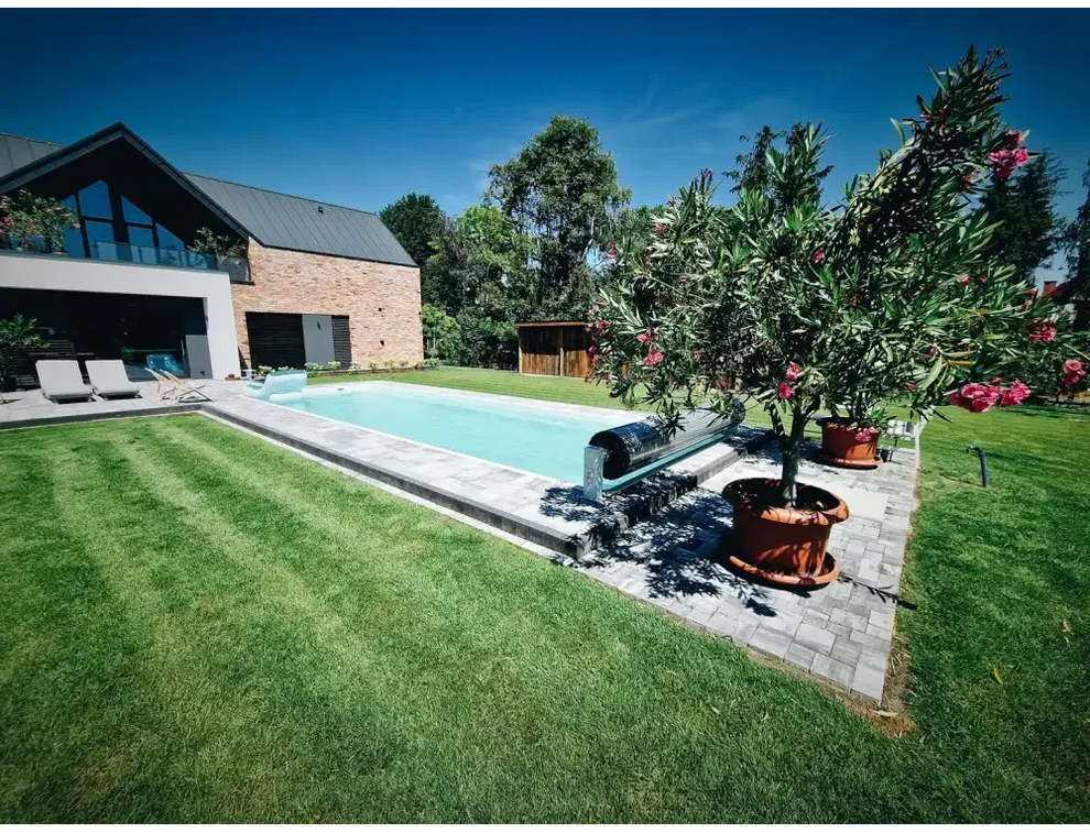 Rektangulär blåsvanflotte för glasfiberpool Jamaika 25x3 75x1 50m med klart vatten och gräsmatta