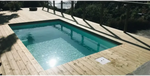Glasfiberpool Mini Victoria med rektangulär form och klart turkost vatten omgivet av ljus trädeck