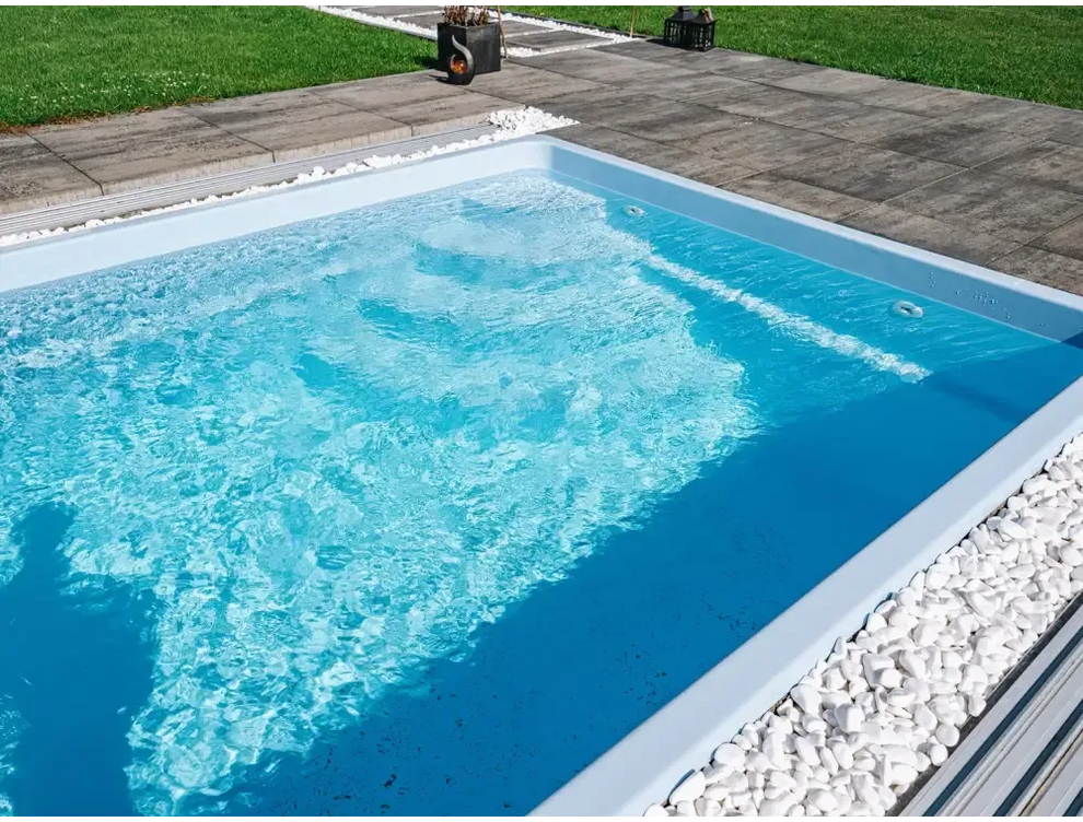 Modern glasfiberpool Papeete med klart blått vatten och vita stenar