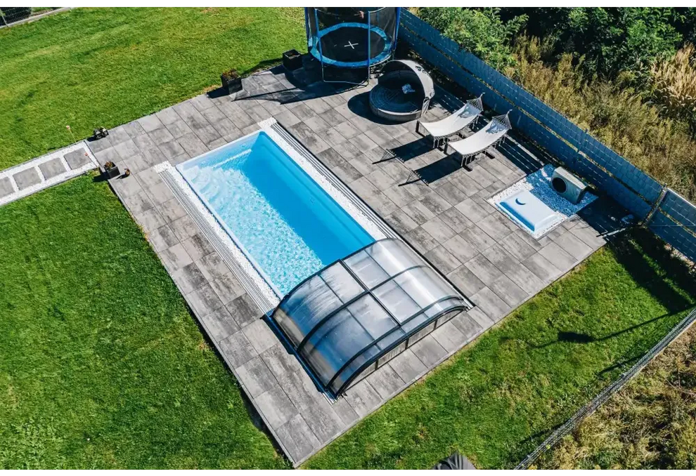 Glasfiberpool Papeete med rektangulär form, klart blått vatten och transparent tak