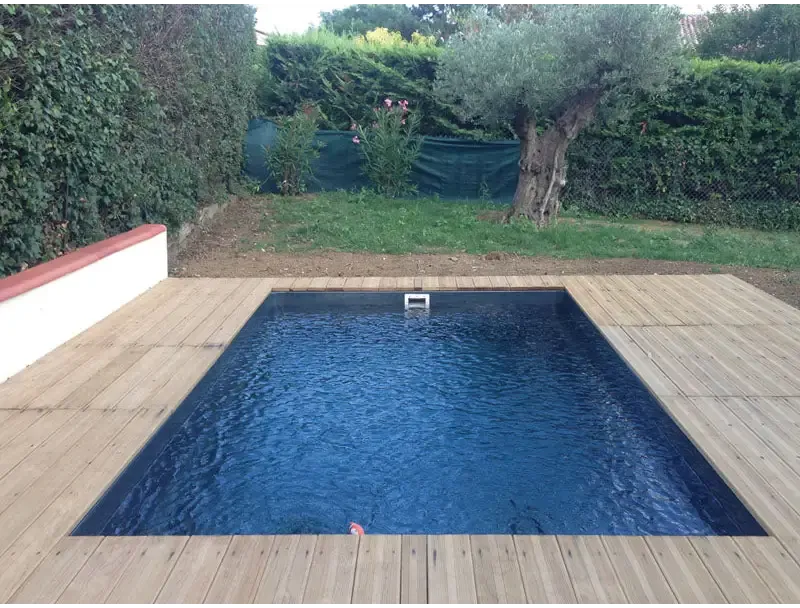 Rektangulär glasfiberpool Saba med djupblått vatten och trädeck