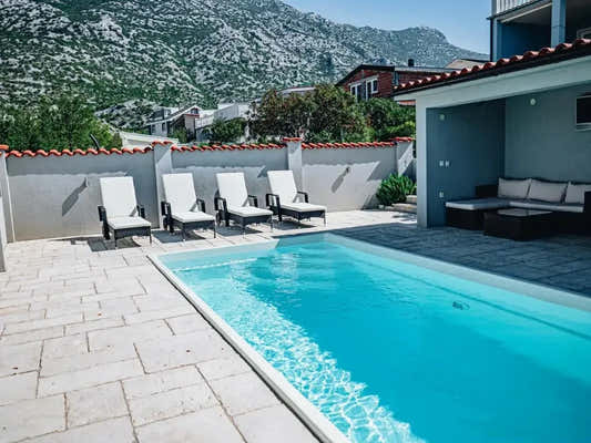 Glasfiberpool Saba med klart blått vatten och vita kaklade kanter Glasfiberpool Saba med klart blått vatten och vita kaklade kanter