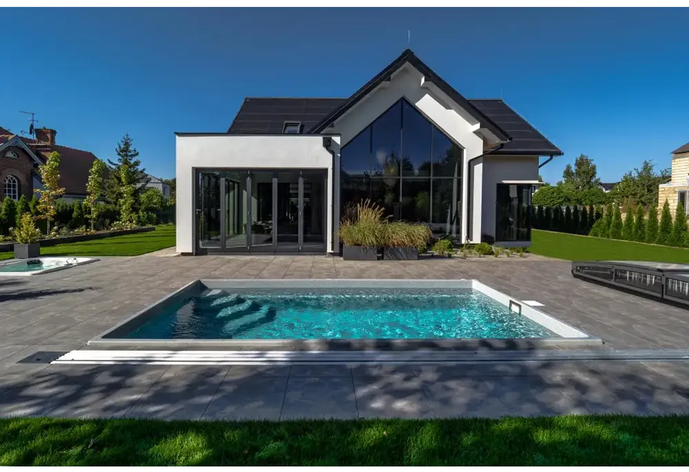 Modern glasfiberpool Saba med klart blått vatten och vita kaklade kanter