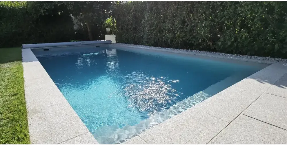 Natura Modena paket med rektangulär pool, klart blått vatten och gröna häckar