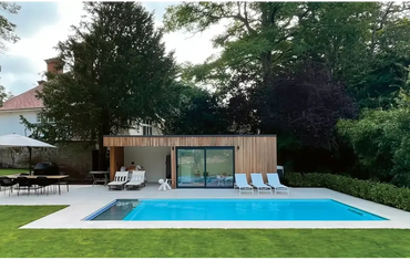 Modern design Leisurepools Cube utomhuspool med träklädd poolhus och stora glasdörrar