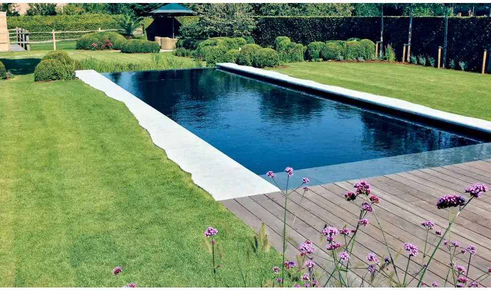 Modern design Leisurepools Cube infinity pool med mörkblått vatten och vita betongkanter