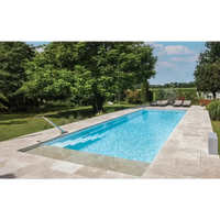 Rektangulär pool med klarblått vatten, ljusbeige stenplattor, modern design, sluttande botten, hög vattenlinje