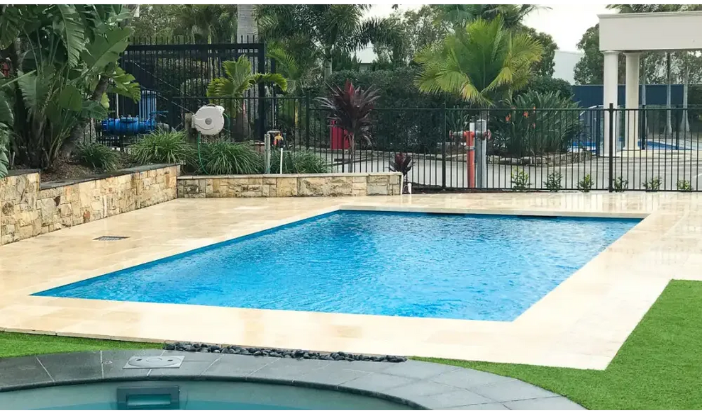 Leisurepools Elite rektangulär modern pool med klarblått vatten och beige sten