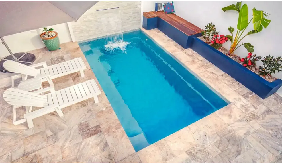 Rektangulär Leisurepools Harmony pool med klart blått vatten och vattenfall