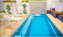 Rektangulär Leisurepools Harmony pool med klart blått vatten och vattenfall