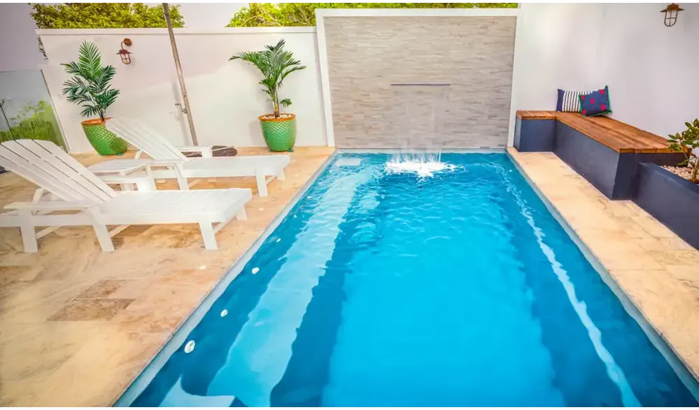 Rektangulär Leisurepools Harmony pool med klart blått vatten och vattenfall