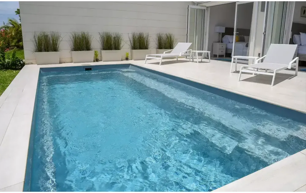 Rektangulär Leisurepools Harmony pool med klart blått vatten och vita kakelkanter