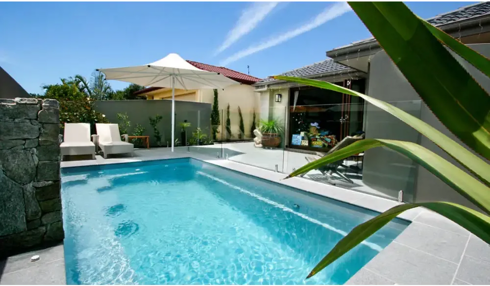 Rektangulär Leisurepools Harmony pool med klart blått vatten och modern glashäck