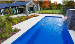 Vibrant blå rektangulär Leisurepools Harmony pool med stenfall och klart vatten