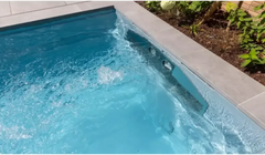 Stilren pooldesign Leisurepools Linear med klart turkost vatten och vattenfall