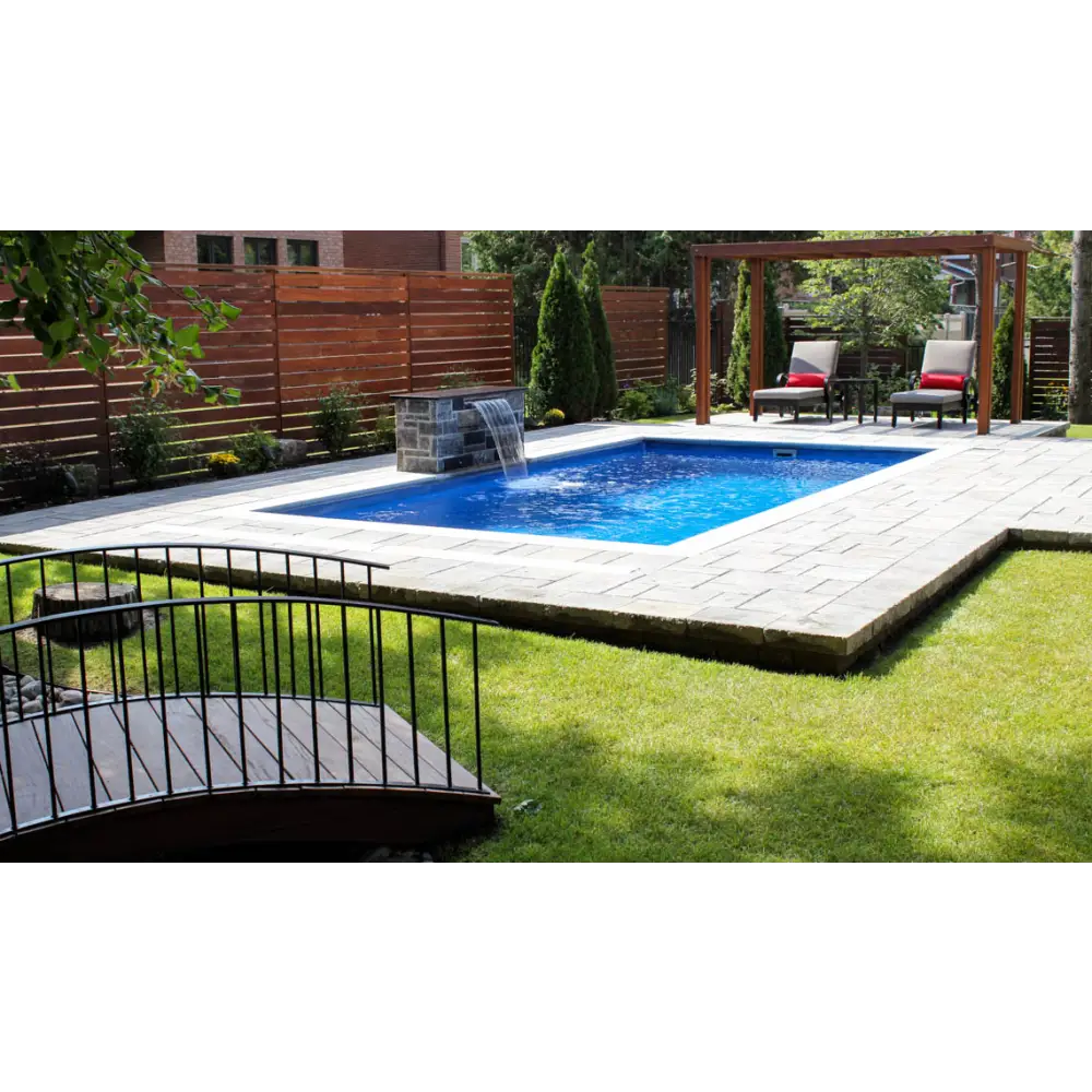 Leisurepools Reflection rektangulär pool med blåvatten, stenplattor och trästaket