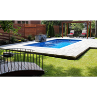 Leisurepools Reflection rektangulär pool med blåvatten, stenplattor och trästaket