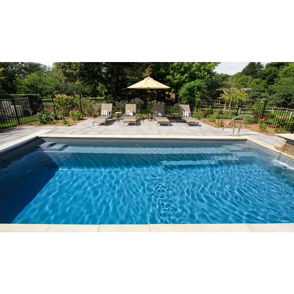 Leisurepools Reflection rektangulär pool med klar blåvatten, stenaltan och solstolar