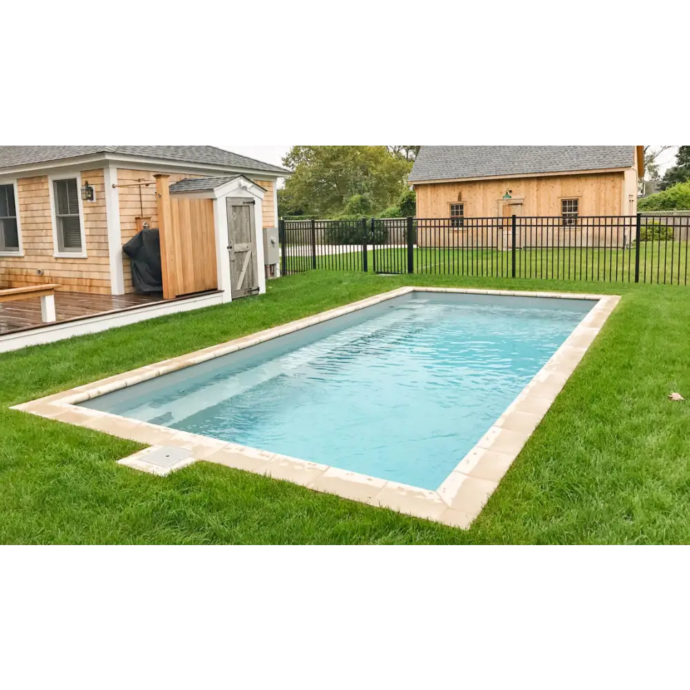 Leisurepools Reflection rektangulär pool med beige kant och blå vatten i gräsmatta