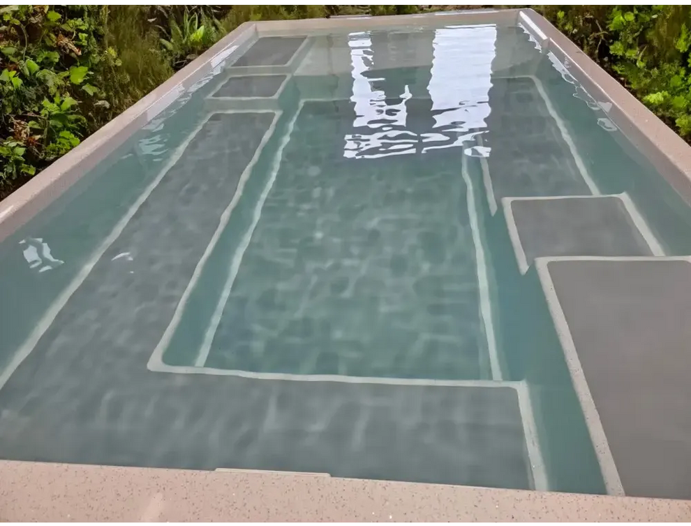 Rektangulär wellness pool ovanmark Mira390 med geometrisk design och grå betongkanter