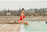 Kvinna i röd baddräkt sitter vid PassionSpa Activity 2 Deep Swim Spa