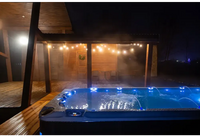 Blå upplyst PassionSpa Activity 2 Swim Spa med jetstrålar och grå texturerad yta