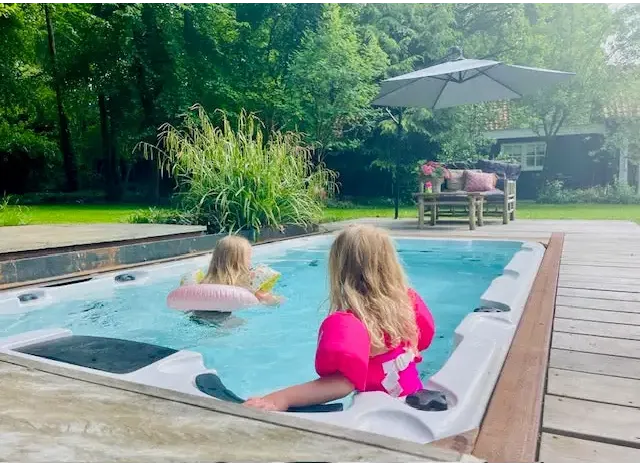Vit PassionSpa Aquatic 1 Swim Spa med barn i bubbelpool på trädäck