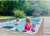 Vit PassionSpa Aquatic 1 Swim Spa med barn i bubbelpool på trädäck