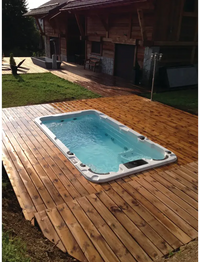 Vit PassionSpa Aquatic 1 Swim Spa i Sport Collection med blåvatten på trädäck