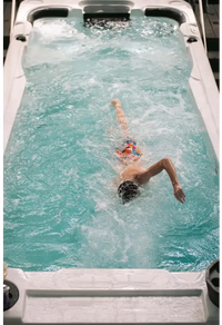 Person simmar i PassionSpa Aquatic 2 Swim Spa med turkost vatten