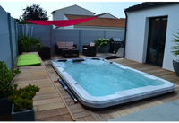 Vit PassionSpa Aquatic 2 Swim Spa i Sport Collection med blåvatten på trädäck