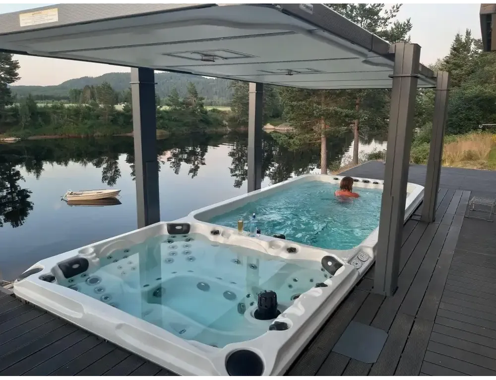 Vit PassionSpa Dynamic Deep Swim Spa – Sport Collection, vit badkar med svarta munstycken under grå tak på trädäck